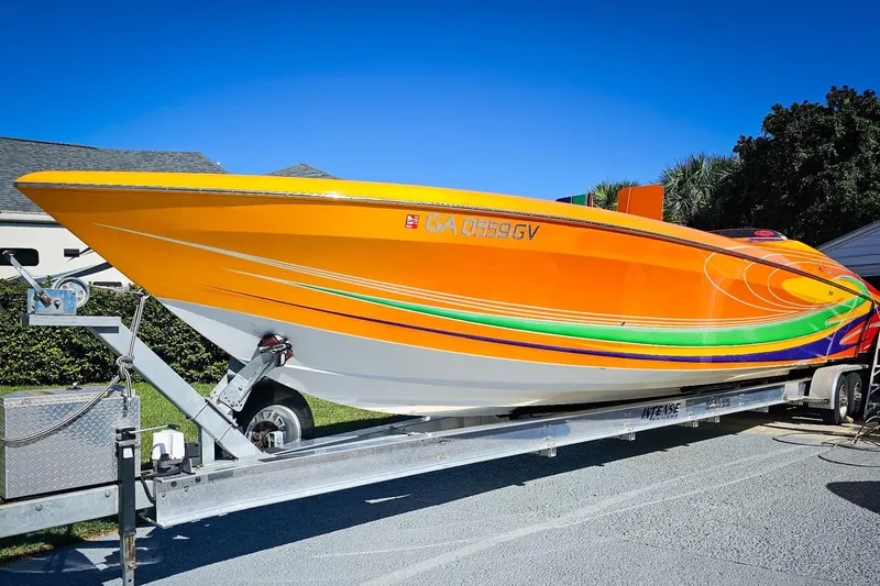 Slide: The Image of 2005 Outerlimits 51 Sport Yacht with vibrant orange and green design on a trailer. - 5