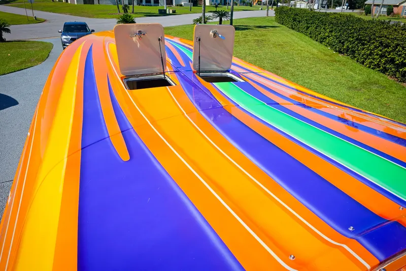 Slide: The Image of Colorful 2005 Outerlimits 51 Sport Yacht with vibrant orange, purple, and green stripes. - 6
