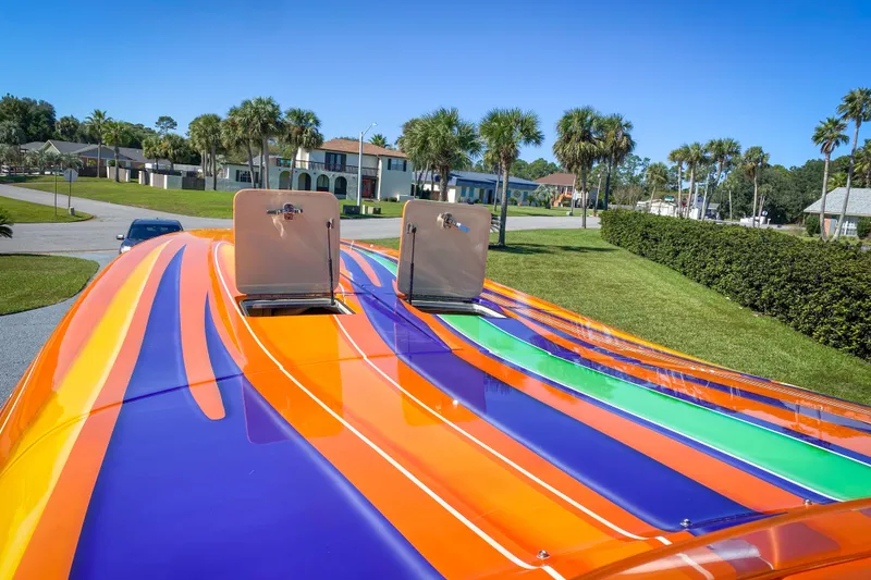 Slide: The Image of Colorful 2005 Outerlimits 51 Sport Yacht with vibrant stripes in a residential area. - 7