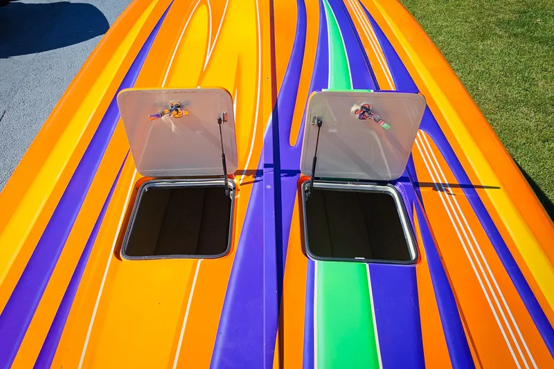 Slide: The Image of Colorful 2005 Outerlimits 51 Sport Yacht deck with open hatches, featuring vibrant orange, purple, and green stripes. - 8