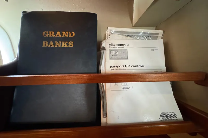 Slide: The Image of Manuals and documents for Grand Banks 42 Motor Yacht, 1989, on a wooden shelf. - 100