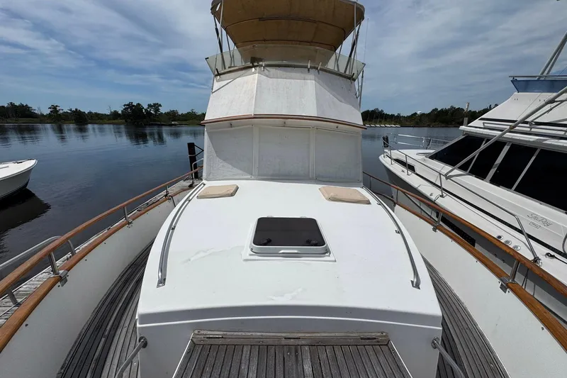Slide: The Image of 1989 Grand Banks 42 Motor Yacht on calm water, showcasing spacious deck and classic design. - 11