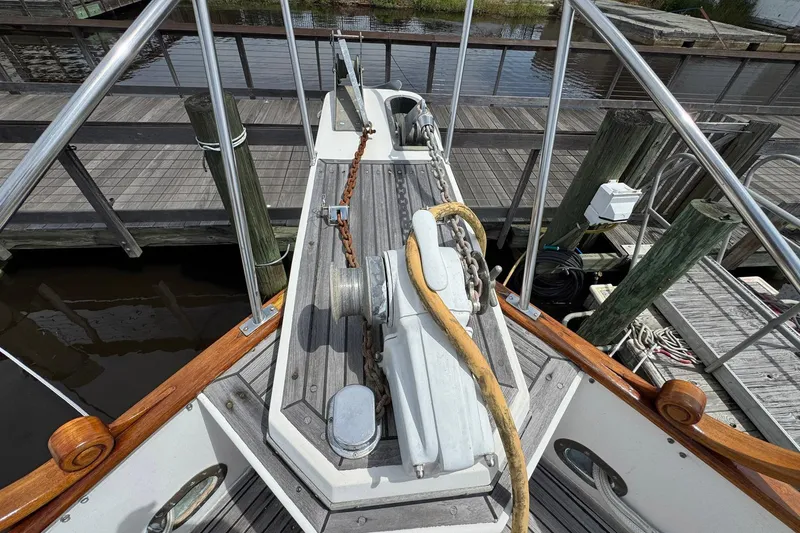 Slide: The Image of 1989 Grand Banks 42 Motor Yacht bow with anchor chain and wooden railings at dock. - 12