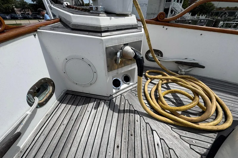 Slide: The Image of 1989 Grand Banks 42 Motor Yacht deck with coiled yellow hose and nautical equipment. - 14