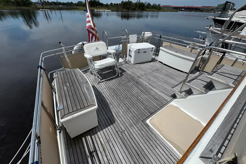 Slide: The Image of 1989 Grand Banks 42 Motor Yacht deck with seating, cooler, and American flag. - 20