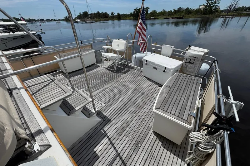 Slide: The Image of 1989 Grand Banks 42 Motor Yacht deck with seating, storage, and American flag. - 21