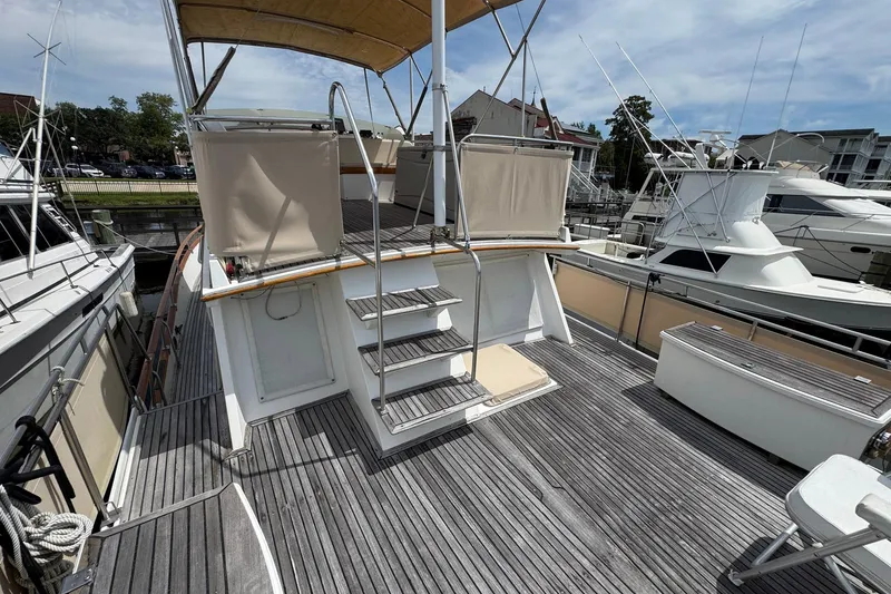 Slide: The Image of 1989 Grand Banks 42 Motor Yacht deck with wooden flooring and canopy, docked at marina. - 22