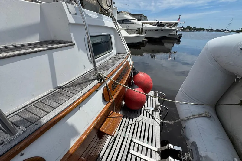 Slide: The Image of 1989 Grand Banks 42 Motor Yacht docked with inflatable boat and red buoys. - 25