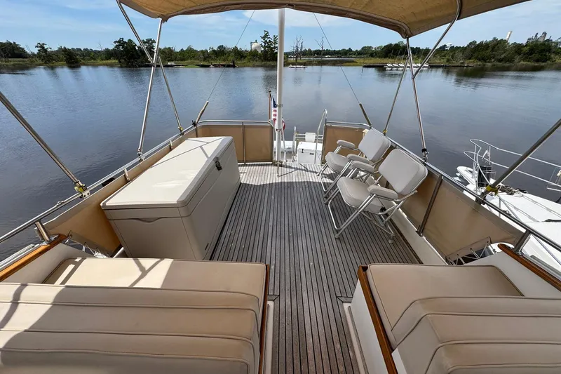 Slide: The Image of 1989 Grand Banks 42 Motor Yacht deck with seating, overlooking serene water and lush greenery. - 32