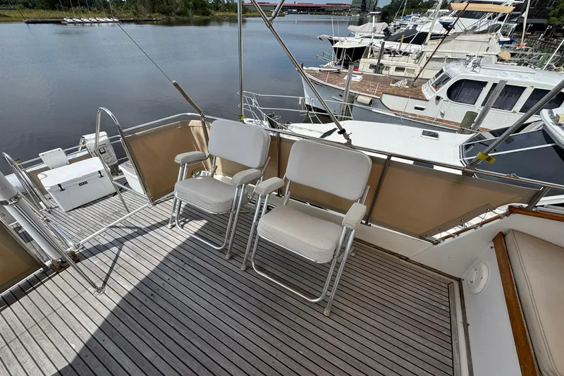 Slide: The Image of 1989 Grand Banks 42 Motor Yacht deck with chairs, docked at marina. - 34