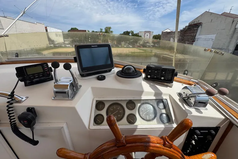 Slide: The Image of Helm of 1989 Grand Banks 42 Motor Yacht with navigation equipment and wooden steering wheel. - 36