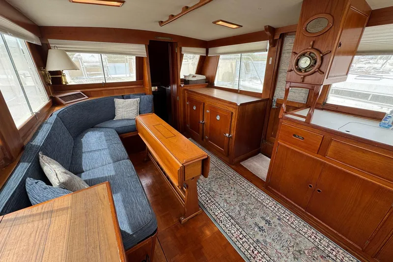 Slide: The Image of 1989 Grand Banks 42 Motor Yacht interior with wood finish, blue seating, and nautical decor. - 40