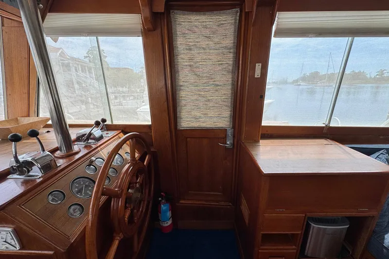 Slide: The Image of 1989 Grand Banks 42 Motor Yacht helm with wooden steering wheel and control panel. - 47