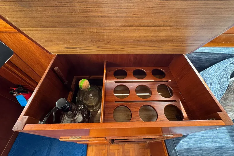 Slide: The Image of Wooden liquor cabinet on 1989 Grand Banks 42 Motor Yacht, featuring bottle storage slots. - 48