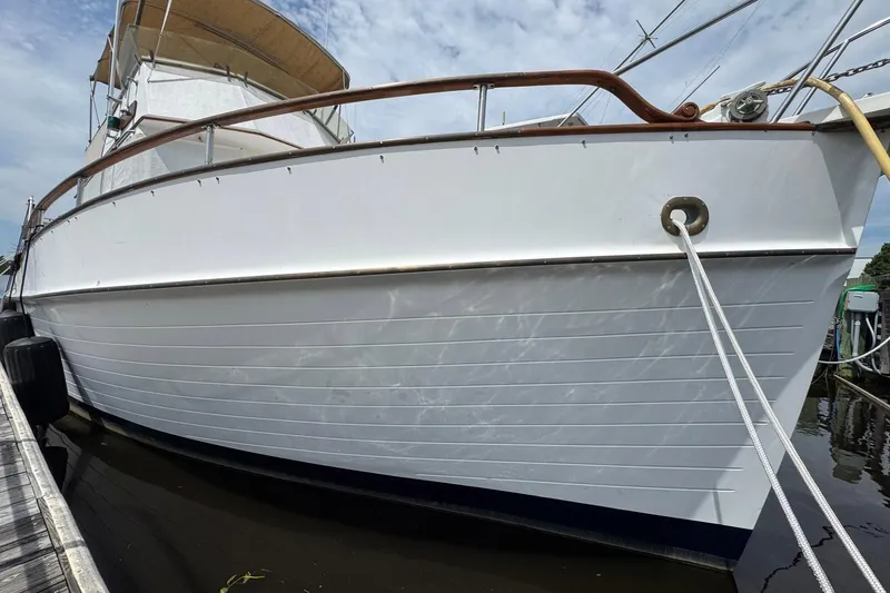 Slide: The Image of 1989 Grand Banks 42 Motor Yacht docked, showcasing classic white hull and wooden railings. - 5