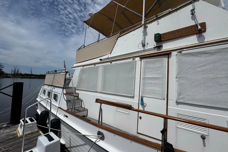 Slide: The Image of 1989 Grand Banks 42 Motor Yacht docked, featuring wooden railings and covered windows. - 6