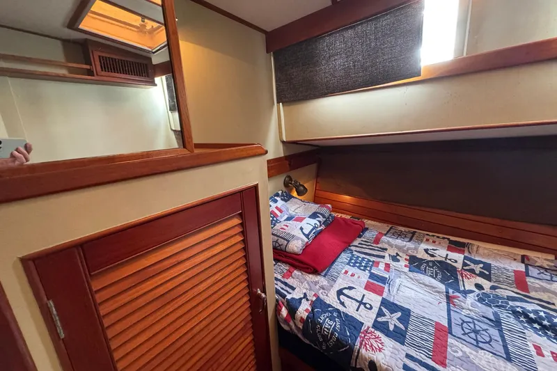 Slide: The Image of Cozy cabin interior of 1989 Grand Banks 42 Motor Yacht with nautical-themed bedding. - 65