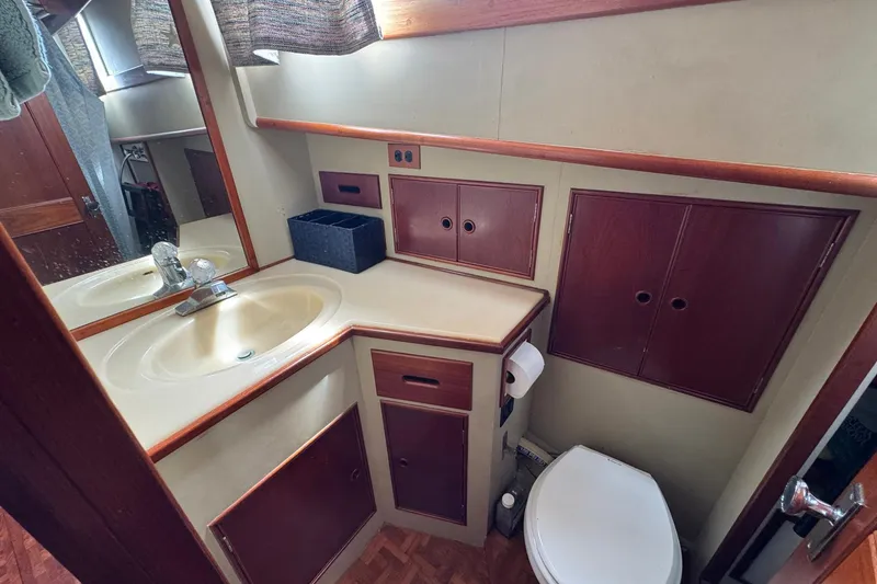 Slide: The Image of 1989 Grand Banks 42 Motor Yacht bathroom with sink, mirror, and storage cabinets. - 67
