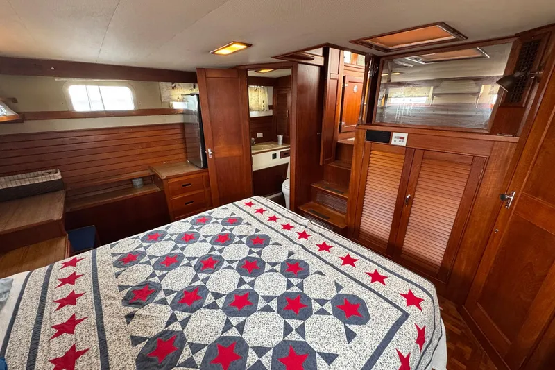 Slide: The Image of Interior of 1989 Grand Banks 42 Motor Yacht with wooden cabinetry and star-patterned bedspread. - 73