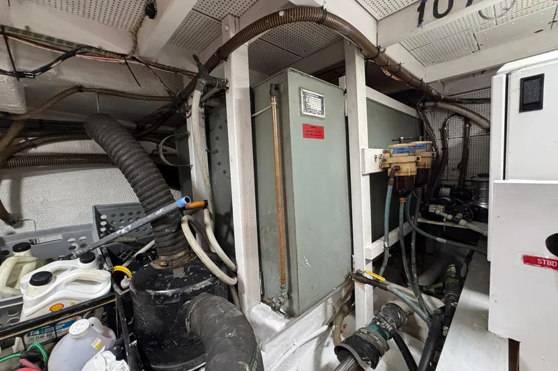 Slide: The Image of Engine room of a 1989 Grand Banks 42 Motor Yacht with various mechanical components. - 94