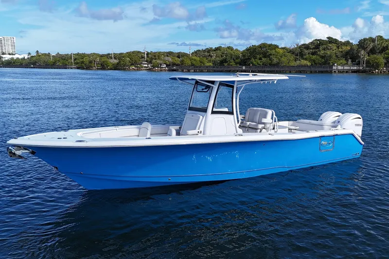 The Image of 2023 Sea Hunt Ultra 305 SE boat on calm water, featuring a sleek blue design. - 1