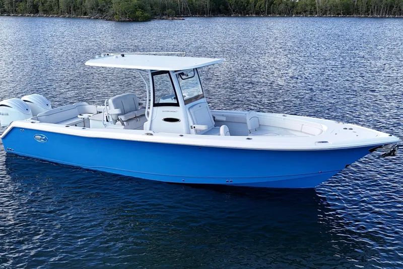 Slide: The Image of 2023 Sea Hunt Ultra 305 SE boat on calm water, featuring sleek blue design. - 10