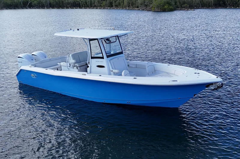 Slide: The Image of 2023 Sea Hunt Ultra 305 SE boat on calm water, featuring sleek blue design. - 11