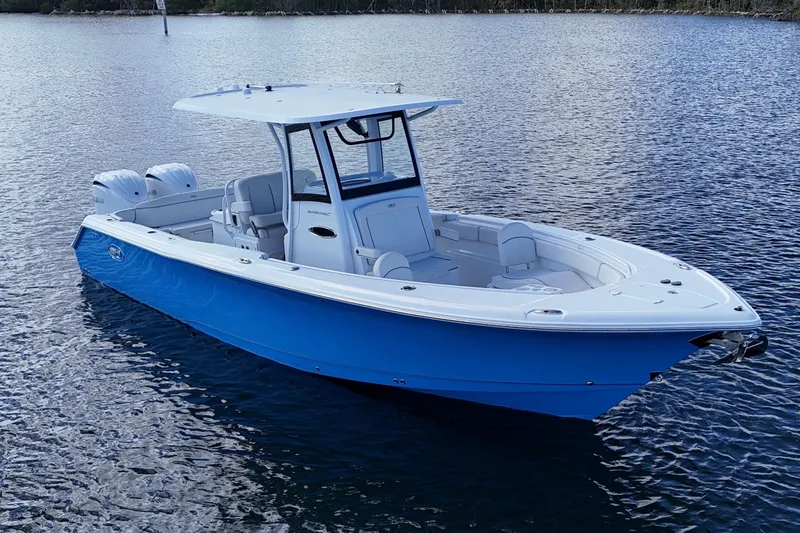 Slide: The Image of 2023 Sea Hunt Ultra 305 SE boat on calm water, featuring a sleek blue and white design. - 12