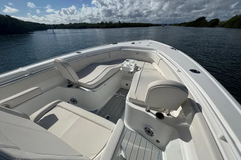 Slide: The Image of 2023 Sea Hunt Ultra 305 SE boat interior with comfortable seating on a calm waterway. - 18