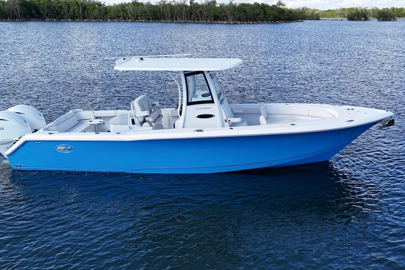 Slide: The Image of 2023 Sea Hunt Ultra 305 SE boat on calm water, featuring a sleek blue design. - 8