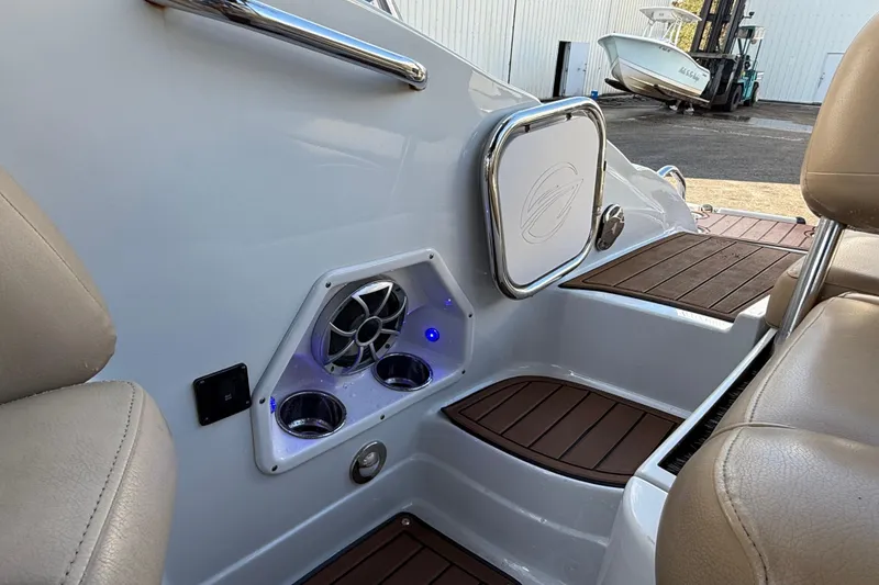 Slide: The Image of 2018 Crownline Eclipse E24 XS boat interior with beige seating and wood-style flooring. - 23