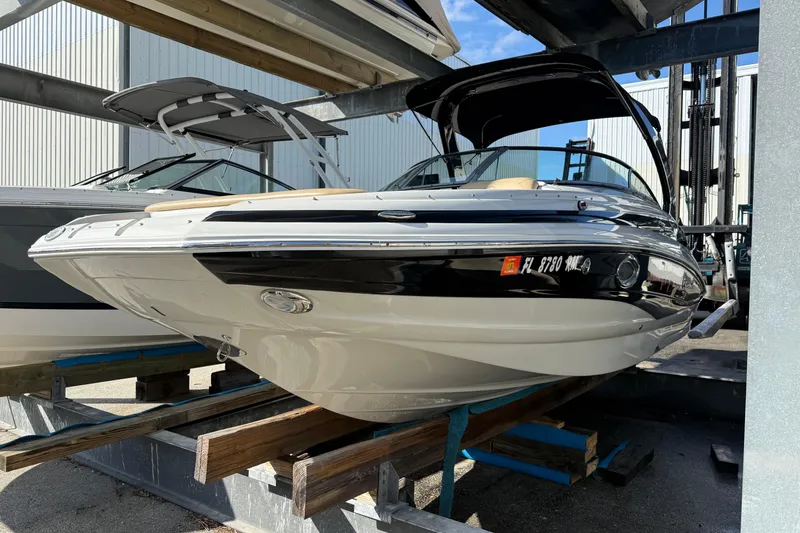 Slide: The Image of 2018 Crownline Eclipse E24 XS boat on a lift, docked beside another vessel. - 3