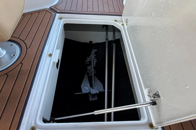 Slide: The Image of Storage compartment on 2018 Crownline Eclipse E24 XS boat with anchor and rods. - 39