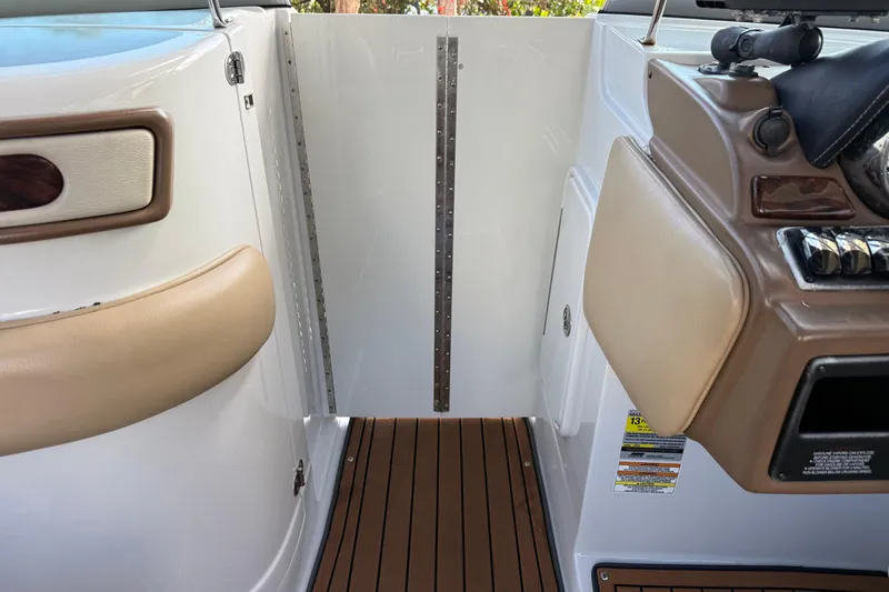 Slide: The Image of 2018 Crownline Eclipse E24 XS boat interior with wood flooring and beige seating. - 47