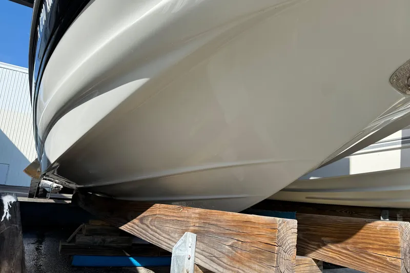 Slide: The Image of 2018 Crownline Eclipse E24 XS boat on a storage rack, black and white exterior. - 5