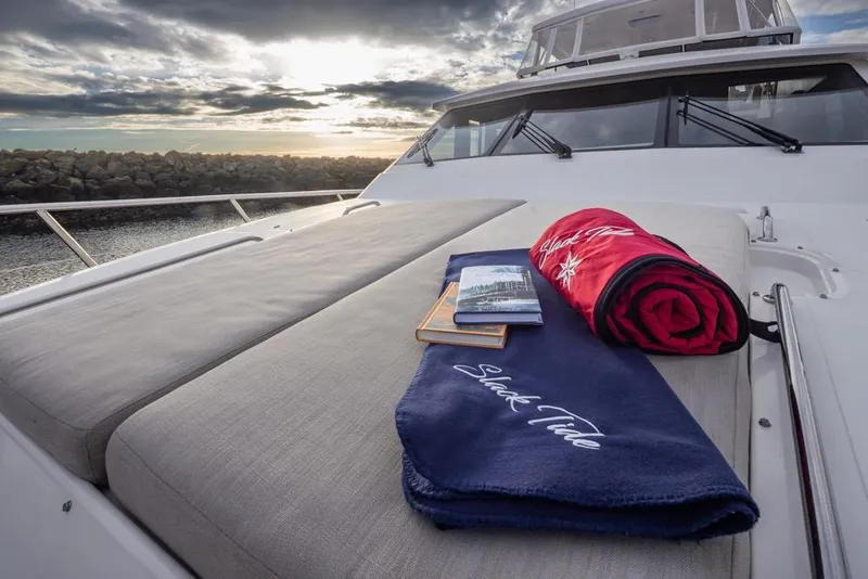 Slide: The Image of Luxurious 2015 Hampton motor yacht deck with towels and book at sunset. - 14