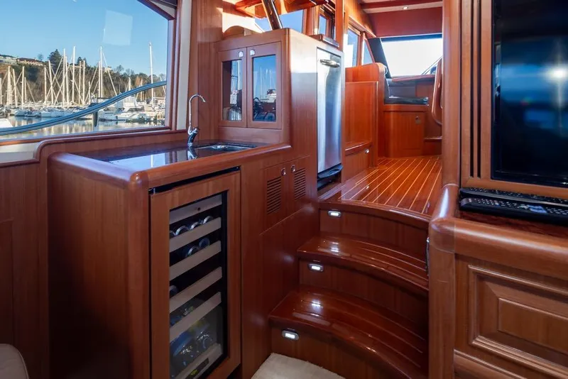 Slide: The Image of Luxurious 2015 Hampton motor yacht interior with wood finish, wine cooler, and marina view. - 20