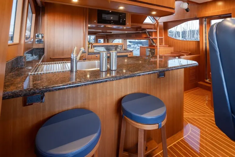 Slide: The Image of Luxurious 2015 Hampton motor yacht interior with elegant wood finishes and modern kitchen amenities. - 23