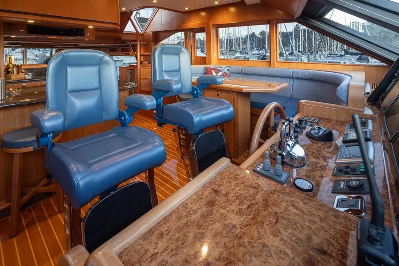 Slide: The Image of Luxurious 2015 Hampton motor yacht interior with blue captain chairs and elegant wood finishes. - 27
