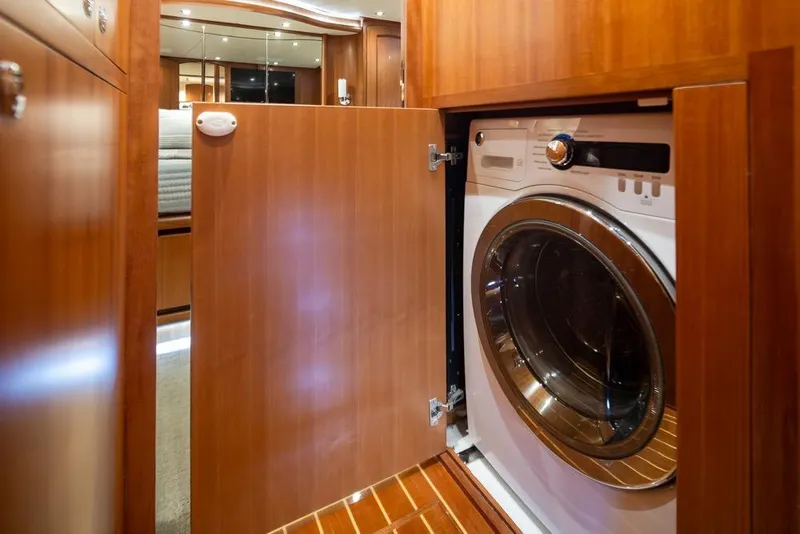 Slide: The Image of Laundry area inside 2015 Hampton motor yacht with wood paneling and modern washer. - 33