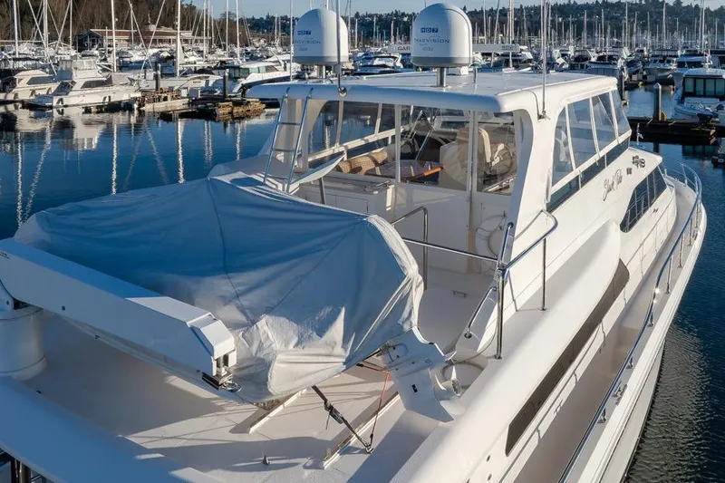Slide: The Image of 2015 Hampton motor yacht docked in a marina, covered equipment on deck. - 4