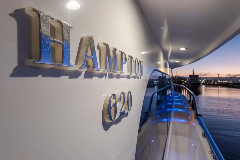 Slide: The Image of 2015 Hampton motor yacht at sunset, docked with illuminated deck. - 6