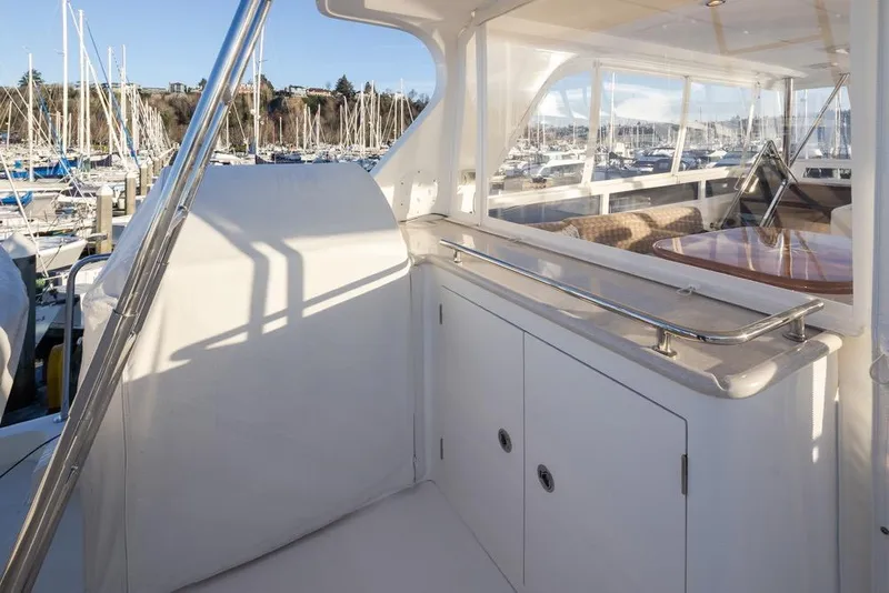 Slide: The Image of 2015 Hampton motor yacht interior with marina view, featuring sleek white cabinetry and polished railings. - 64