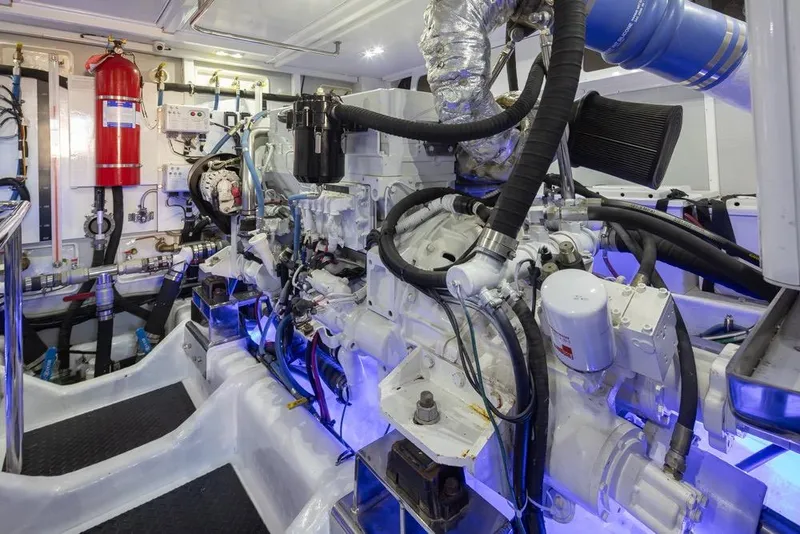 Slide: The Image of Engine room of a 2015 Hampton motor yacht, featuring complex machinery and piping. - 74