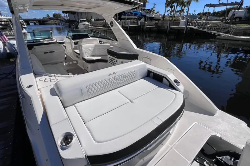 Slide: The Image of 2019 Sea Ray SLX 310 Outboard with dual Mercury engines, docked in sunlight. - 14