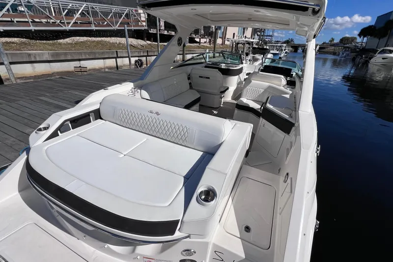Slide: The Image of 2019 Sea Ray SLX 310 Outboard luxury boat interior with plush seating at dock. - 15