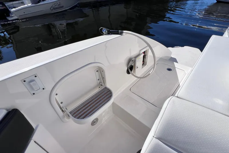 Slide: The Image of 2019 Sea Ray SLX 310 Outboard boat interior with white seating and storage compartment. - 21