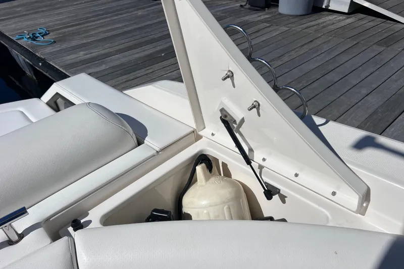 Slide: The Image of 2019 Sea Ray SLX 310 Outboard boat with white seating and metal cup holders. - 30