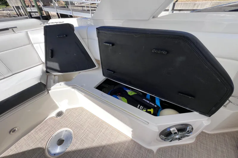 Slide: The Image of 2019 Sea Ray SLX 310 Outboard interior storage compartment with life jackets and speaker. - 32