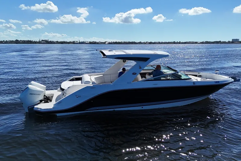 Slide: The Image of 2019 Sea Ray SLX 310 Outboard cruising on a sunny day, with clear blue skies. - 4